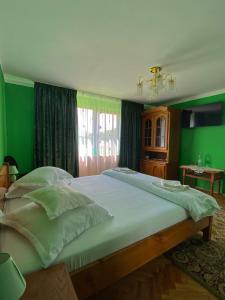 巴亚德菲耶尔Pensiunea Angelica的一间卧室设有一张带绿色墙壁的大床