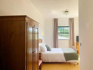 维尼艾什Vinhais Hotel的一间卧室设有一张床和一个窗口
