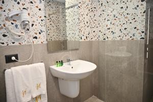 都拉斯Hotel Vino的浴室配有白色水槽和淋浴。