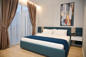 都拉斯Hotel Vino的卧室配有蓝色和白色的床和窗户。