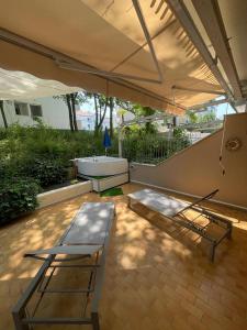 卡奥莱Casa Roberta con favolosa terrazza privata的一个带遮阳伞、长凳和浴缸的庭院