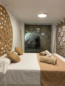 阿利坎特Ereta rooms的一间卧室设有两张床和石墙