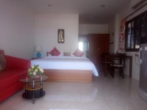 卡塔海滩达简易别墅的一间卧室配有一张大床和一张红色的沙发