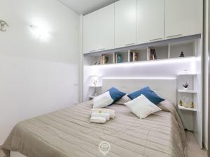 夸尔图-圣埃莱娜Zaffiro Apartment的白色卧室配有蓝色和白色枕头的床