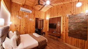 瑞诗凯诗Qcent Woods Resort & Spa, Rishikesh的一间带木墙的卧室和一张位于客房内的床