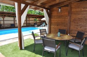 迈泽克韦什德Garden Villa Zsóry的一个带桌椅的庭院和一个游泳池