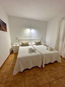埃斯普霍斯AT Espalmador Formentera rustick的一间卧室配有两张带白色床单的床