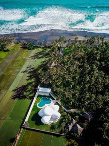 塔巴南The Cloud Beachfront Villa Tabanan的享有带游泳池和海洋的度假村的空中景致