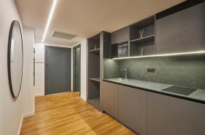 萨洛Rentalmar Suites Salou Families Only的厨房配有黑色橱柜和木地板