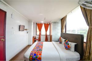 SaluaFabHotel Raj Darbar的一间卧室设有一张大床和一个窗户。