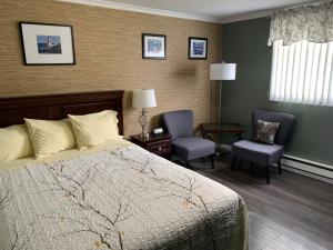 Heartʼs ContentLegges Motel & Restaurant的酒店客房,配有一张床和两把椅子