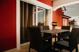 吉格涅斯科斐耶Villa Sunset Pool & Spa apartments的一张桌子和椅子,上面有一杯葡萄酒