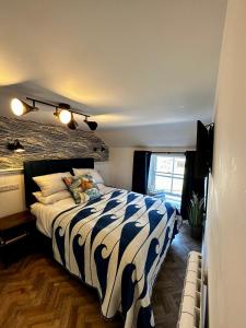 PolruanThe Lugger Inn的一间卧室配有一张带蓝色和白色棉被的床