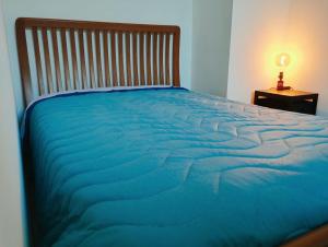 迪亚诺卡斯泰洛Casa Relax Diano Castello的一张带木制床头板和桌子的大型蓝色床