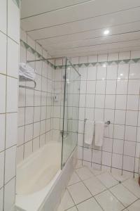 赫尔格达Dexon Roma Hotel的白色瓷砖浴室设有淋浴和浴缸。