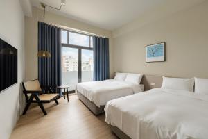 彰化市Timios Inn 提米好旅的酒店客房设有两张床和窗户。