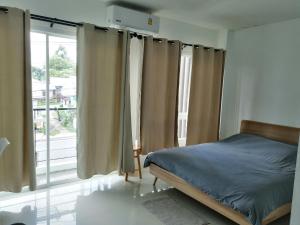 拉威海滩Baan7984 Rawai的一间卧室设有一张床和一个大窗户
