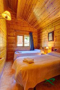 希塞雷拉希瑟雷拉公园简易别墅露营地的小木屋内一间卧室,配有两张床