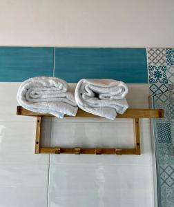 伊斯基亚Dimora Schiappone的浴室的木架上摆放着两条毛巾