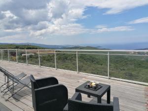 波尔蒂乔CHAMBRE EVASION VUE EXCEPTIONNELLE PORTICCIO的阳台配有桌椅,享有风景。