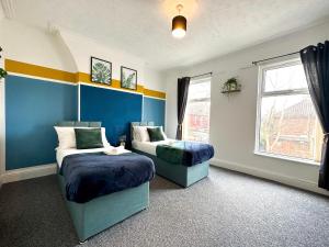 利物浦Air Host and Stay - Phillimore - sleeps 9, mins from city free parking的一间卧室设有两张床和窗户。