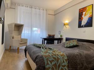 BeaurepaireL'EMBLEME - BOUTIQUE HOTEL的一间卧室配有一张床、一把椅子和一张书桌