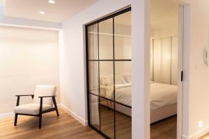 卡利斯托斯Underground Luxury Living的卧室设有玻璃隔板、椅子和床