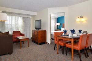 奥罗拉Residence Inn by Marriott Denver Airport at Gateway Park的酒店客房设有餐桌和一间卧室。