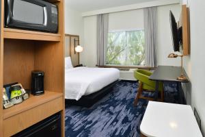 夏洛特Fairfield Inn & Suites by Marriott Charlotte University Research Park的一间酒店客房,配有一张床和一台电视