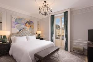 圣塞瓦斯蒂安Hotel Maria Cristina, a Luxury Collection Hotel, San Sebastian的卧室配有白色的床和吊灯。