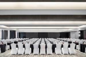 成都成都天府新区福朋喜来登酒店的一间会议室,配有白色椅子和舞台