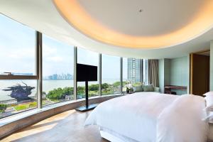 杭州杭州滨江银泰喜来登大酒店的一间卧室设有一张大床和大窗户