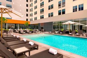 达拉斯达拉斯爱田雅乐轩酒店的一个带躺椅的游泳池和一间酒店