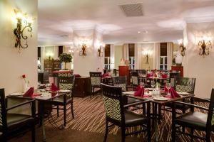 布兰太尔瑞雅尔普罗提酒店的用餐室配有桌椅和红色餐巾