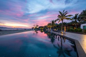 港生Rayong Marriott Resort & Spa的海滩上的游泳池,享有日落美景