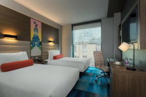 都柏林Aloft Dublin City的酒店客房设有两张床和窗户。