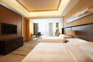 固安县廊坊固安福朋喜来登酒店的酒店客房设有两张床和一台平面电视。