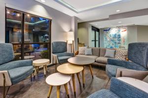 纳什维尔TownePlace Suites by Marriott Nashville Airport的一间设有蓝色椅子和桌子的等候室