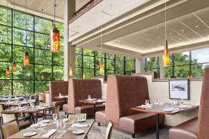 凯霍加福尔斯阿克伦凯霍加福尔斯喜来登套房酒店的餐厅设有桌椅和大窗户。