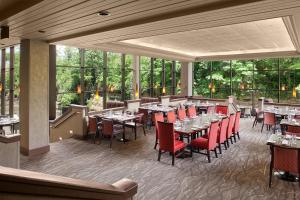 凯霍加福尔斯阿克伦凯霍加福尔斯喜来登套房酒店的餐厅设有桌子和红色椅子以及窗户。