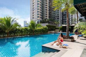 曼谷曼谷素坤逸公园万豪行政公寓的坐在游泳池旁的红比基尼的女人