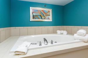西得梅因德梅因西费尔菲尔德客栈的浴室配有浴缸,墙上挂有绘画作品