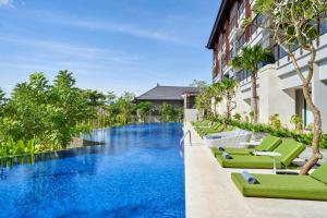 努沙杜瓦Renaissance Bali Nusa Dua Resort的一座带绿色躺椅的酒店游泳池