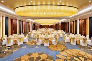浦那Sheraton Grand Pune Bund Garden Hotel的宴会厅,室内配有白色的桌椅