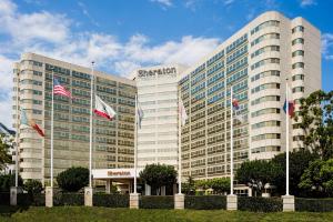 洛杉矶Sheraton Gateway Los Angeles Hotel的前面有旗帜的大建筑