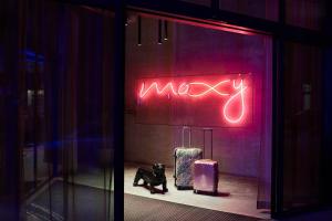 布鲁塞尔Moxy Brussels City Center的存放在装有行李的商店窗口的 ⁇ 虹灯标志