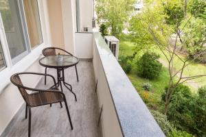 布尔加斯Alagen Apartments Burgas的美景阳台配有小桌子和椅子
