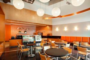 波莫纳Sheraton Fairplex Suites & Conference Center的用餐室配有桌椅和灯光