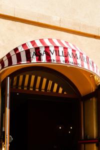 阿尔盖罗Sella&Mosca Casa Villamarina的大楼门上方的红白色遮篷
