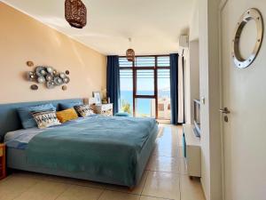 圣弗拉斯Dolce Vita Blue Boho, Premium Apartment with seaview的一间卧室设有蓝色的床和大窗户